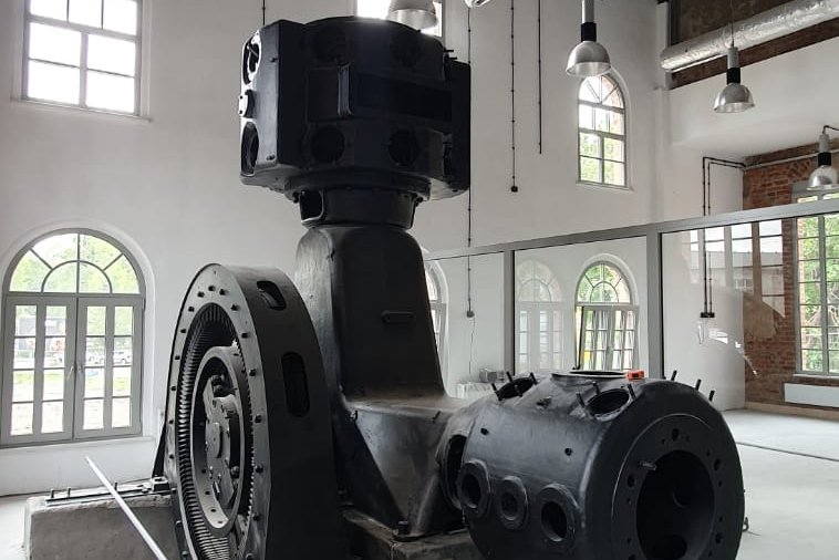 Ignacy 05 2020 11 Maszyna górnicza - ekspozycja w wyremontowanych wnętrzach dawnej kopalni. Na drugim planie biała ściana z oknami.