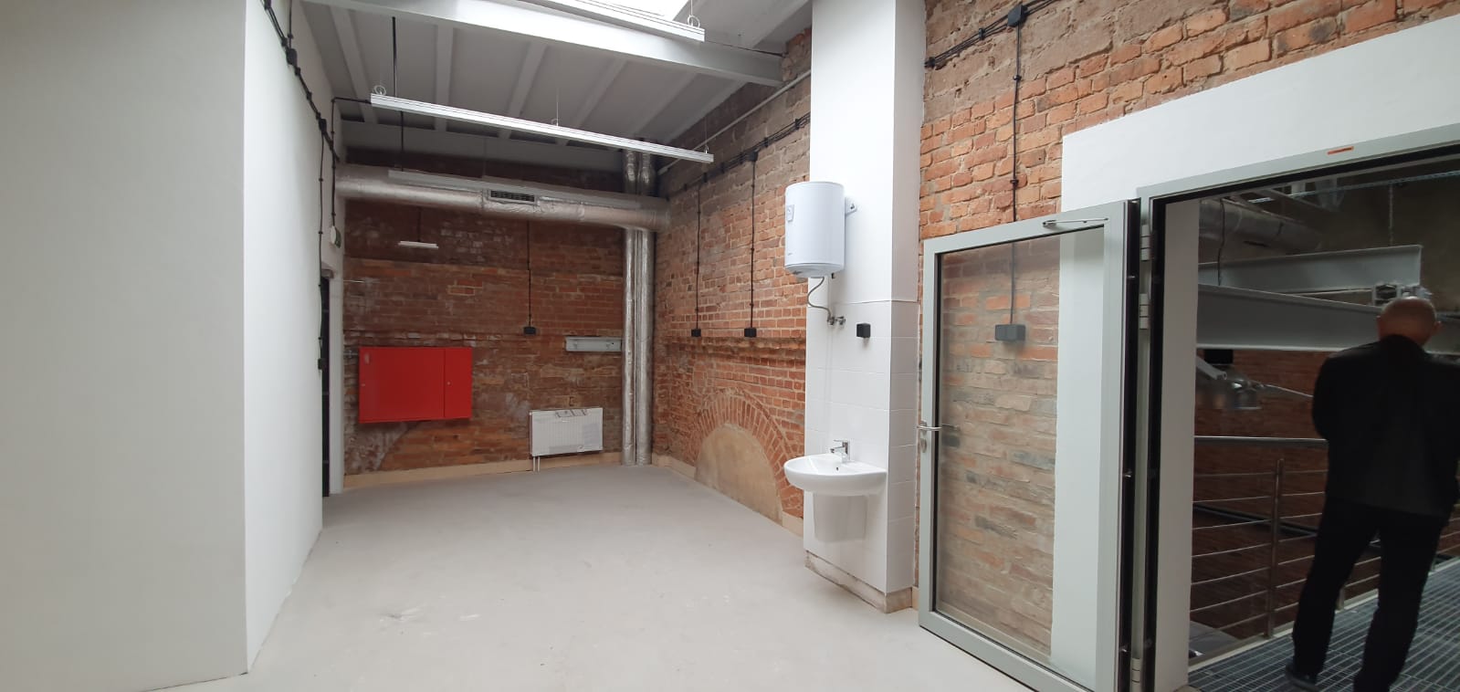 Ignacy 05 2020 6 Industrialne wnętrze, ściany z czerwonej cegły, stalowe konstrukcje. Część ścian otynkowanych na biało.